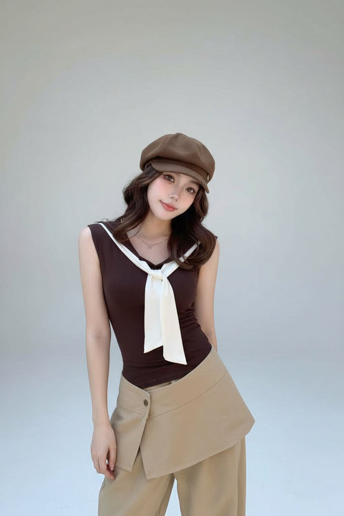 Woman in a vintage outfit with a brown top and beige pants, standing outdoors.