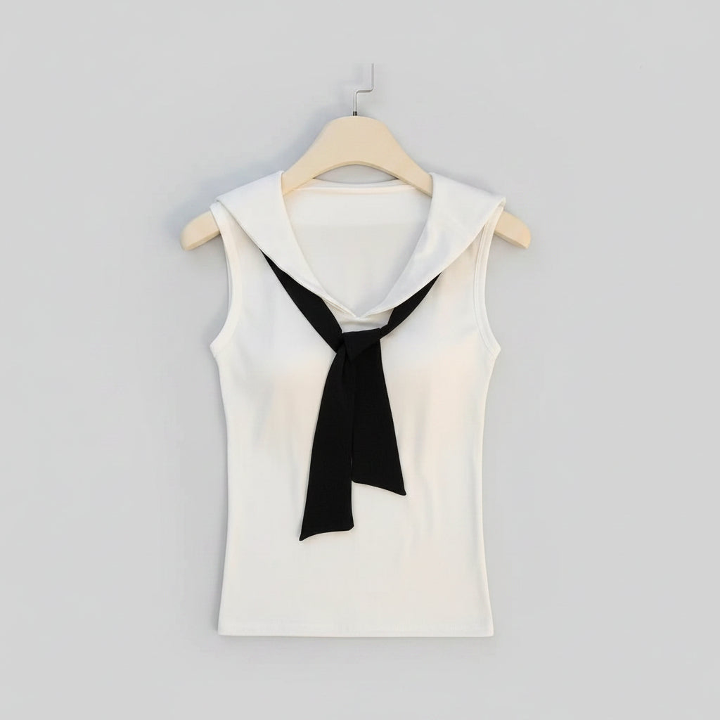 White sleeveless top with black tie on a hanger over an open cardboard box.