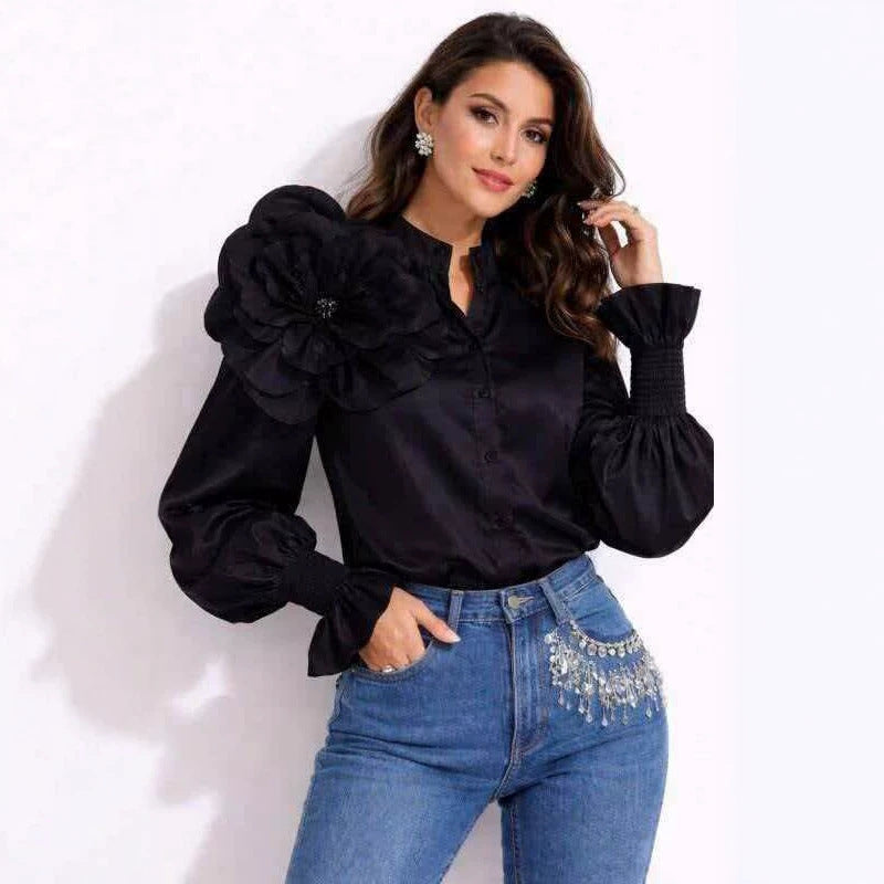Woman wearing a black blouse with floral details and blue jeans on a white background